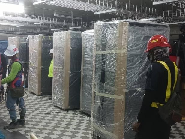 Alafbaru crew unpacking and positioning equipment racks
